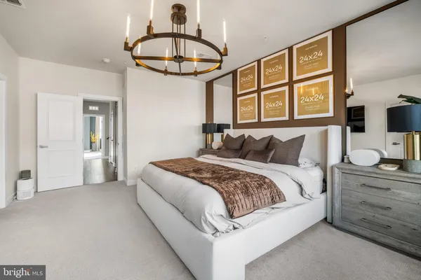 a bedroom with a large bed and a chandelier