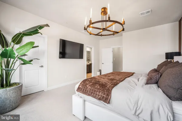 a bedroom with a bed and a potted plant