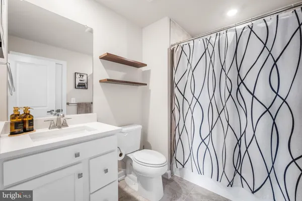 a bathroom with a sink a toilet and shower curtain