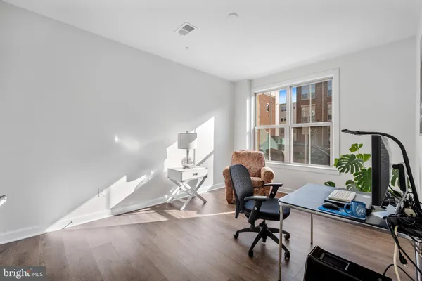 a view of a workspace with furniture and a window