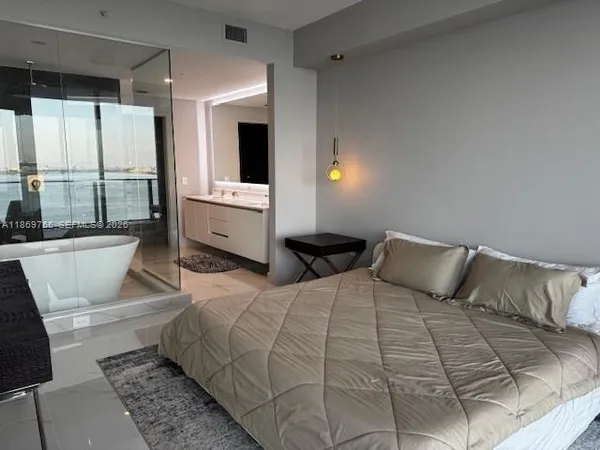 a bathroom with a tub a double vanity sink and a mirror