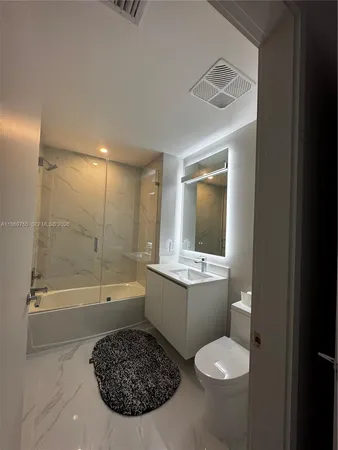 a bathroom with a sink mirror toilet and bathtub