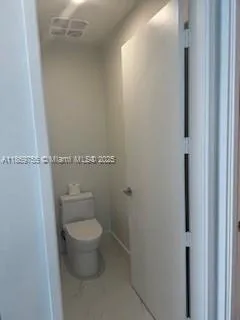 a white toilet sitting next to a shower