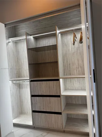 a view of walk in closet with empty racks