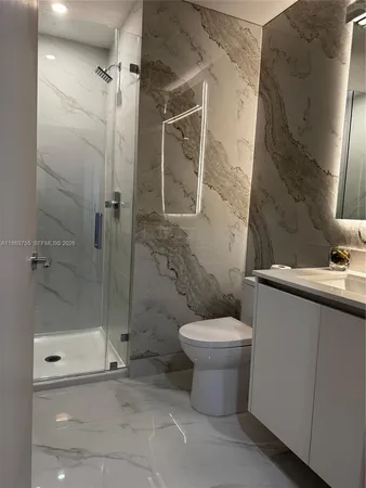 a bed sitting in a bedroom next to a bathroom