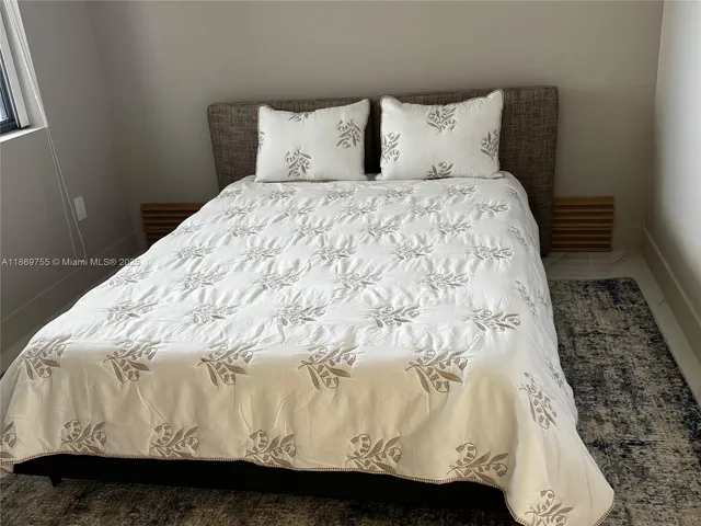 a bed sitting in a bedroom next to a window