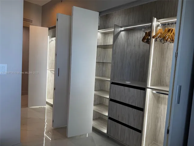 a view of walk in closet with empty racks