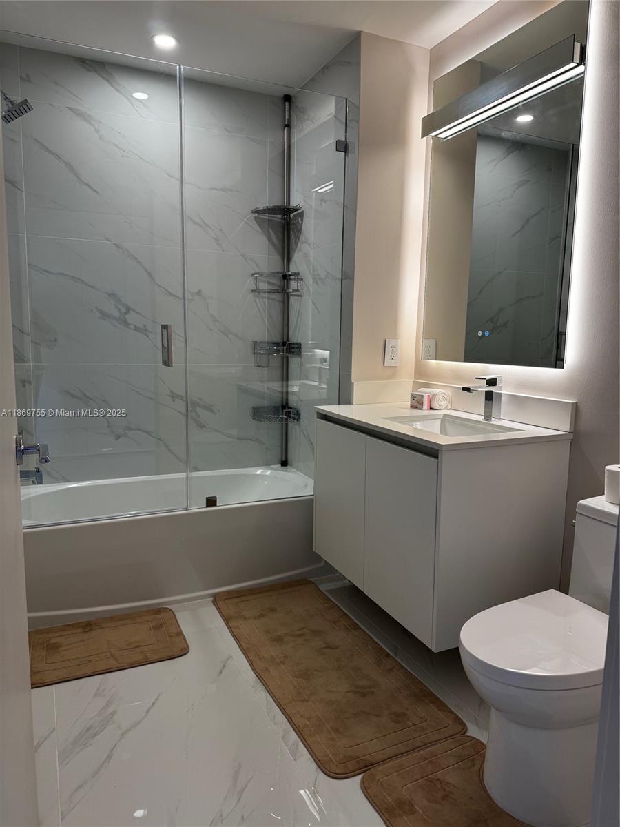 700 Northeast 24th Street, Unit 2206 Miami, FL 33137 - Photo 39 of 41 a bathroom with a sink mirror toilet and bathtub