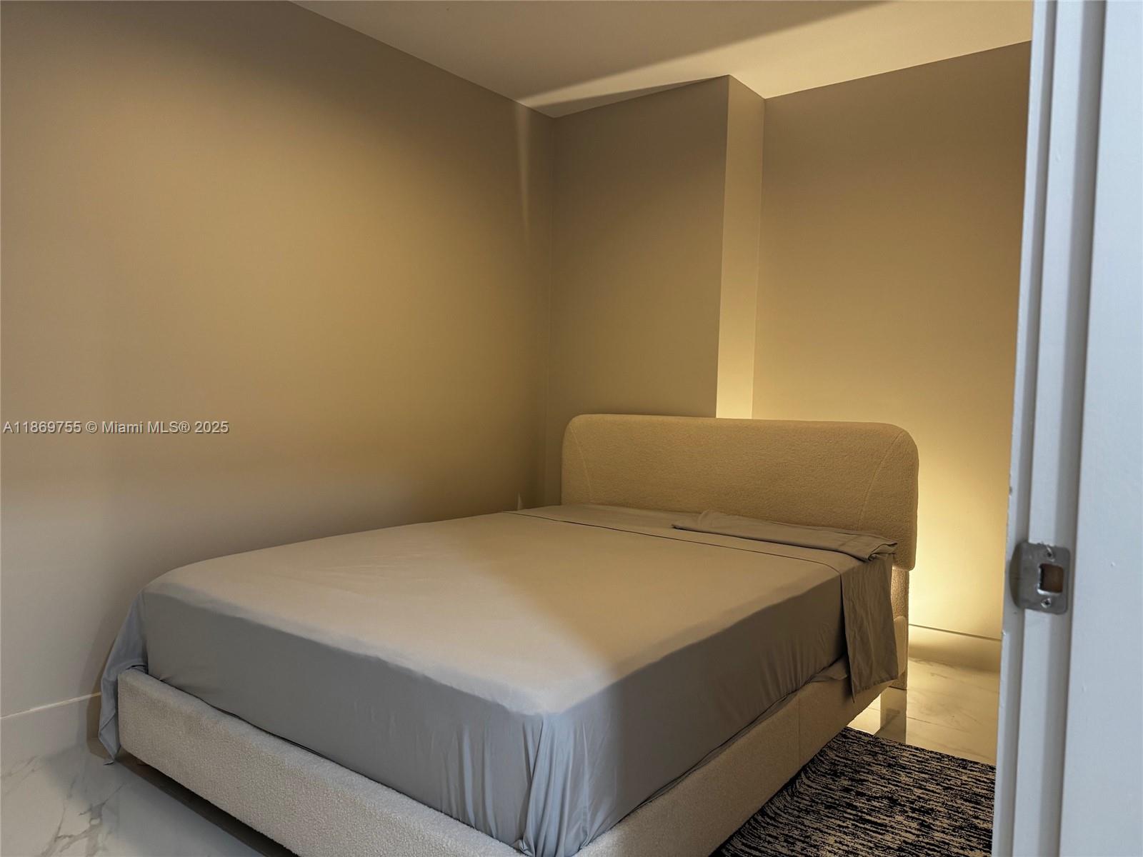 700 Northeast 24th Street, Unit 2206 Miami, FL 33137 - Photo 40 of 41 a bed sitting in a bedroom next to a bathroom