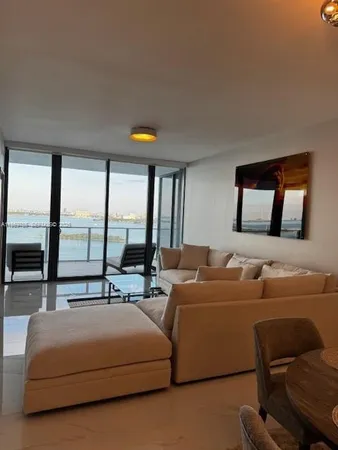 a living room with furniture and large windows