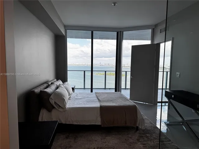 a bedroom with a bed and a large window