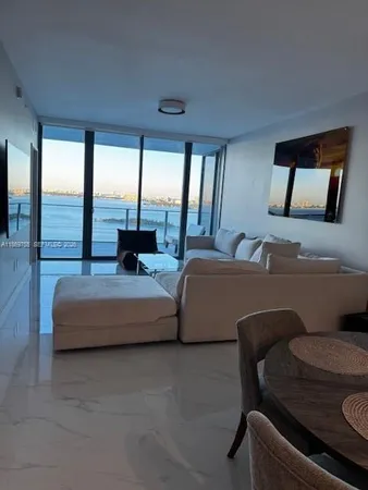 a living room with furniture and a floor to ceiling window