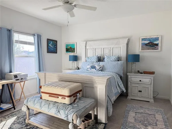 a spacious bedroom with a bed and a chandelier