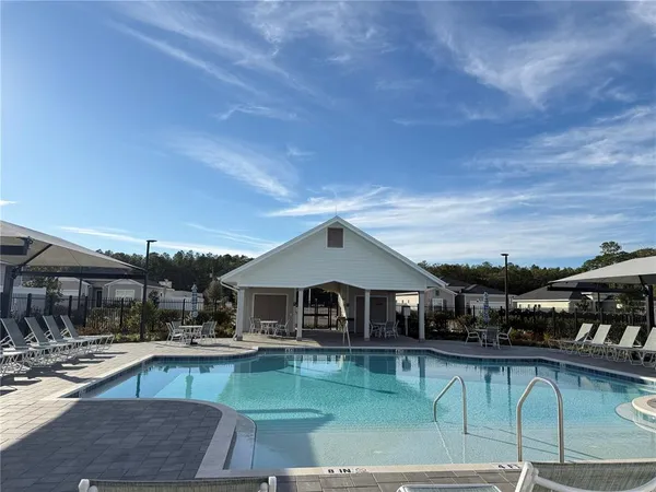 a front view of house with swimming pool having outdoor seating