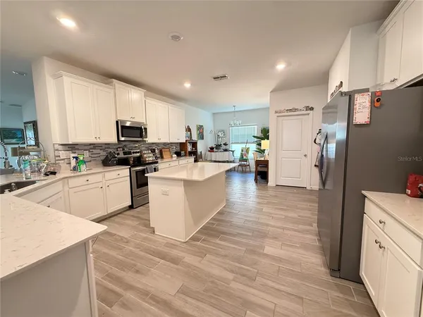 a kitchen with stainless steel appliances a refrigerator sink and cabinets