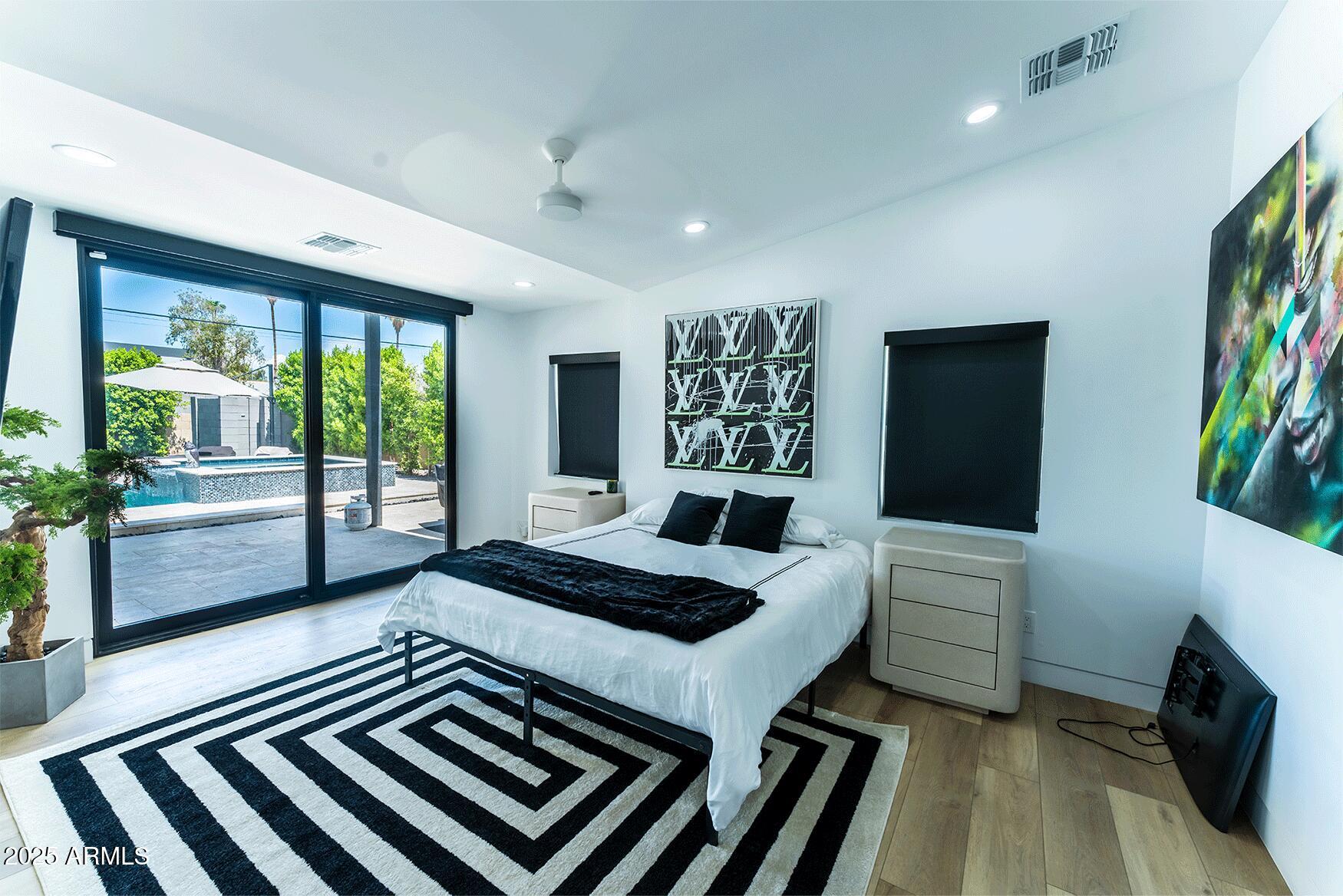 4334 East Lewis Avenue Phoenix, AZ 85008 - Photo 14 of 26 a bedroom with a bed and a flat tv screen on dresser