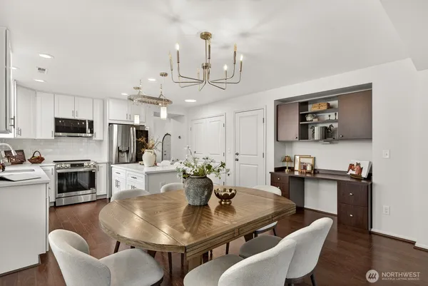 a kitchen with stainless steel appliances granite countertop a dining table and chairs