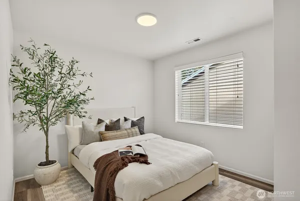 a bedroom with bed and a potted plant