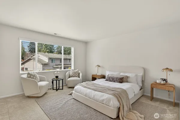 a bedroom with furniture and a large window