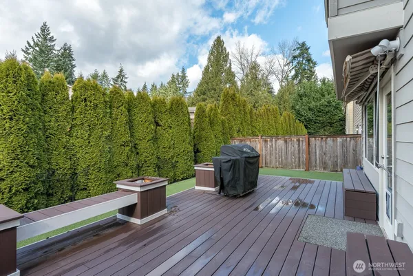 a view of a deck with wooden floor and fence with a bench