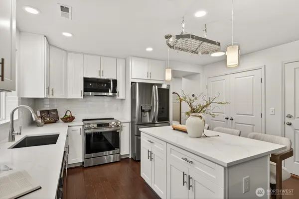 a kitchen with a sink a counter space cabinets and stainless steel appliances