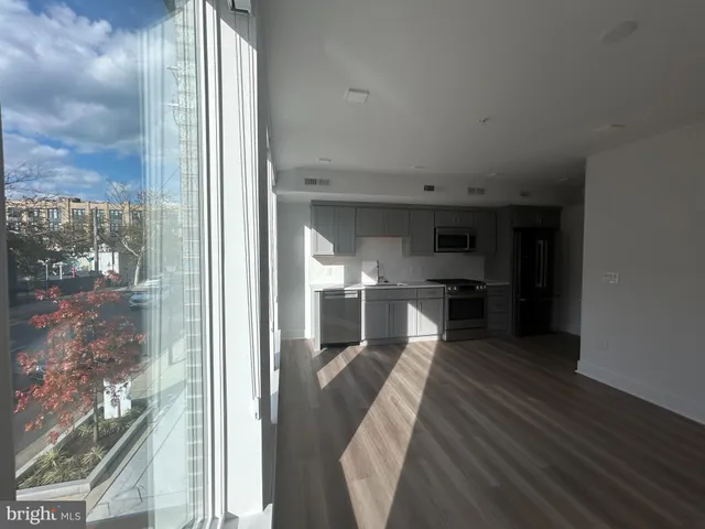 a view of a kitchen with kitchen island wooden floor and electronic appliances