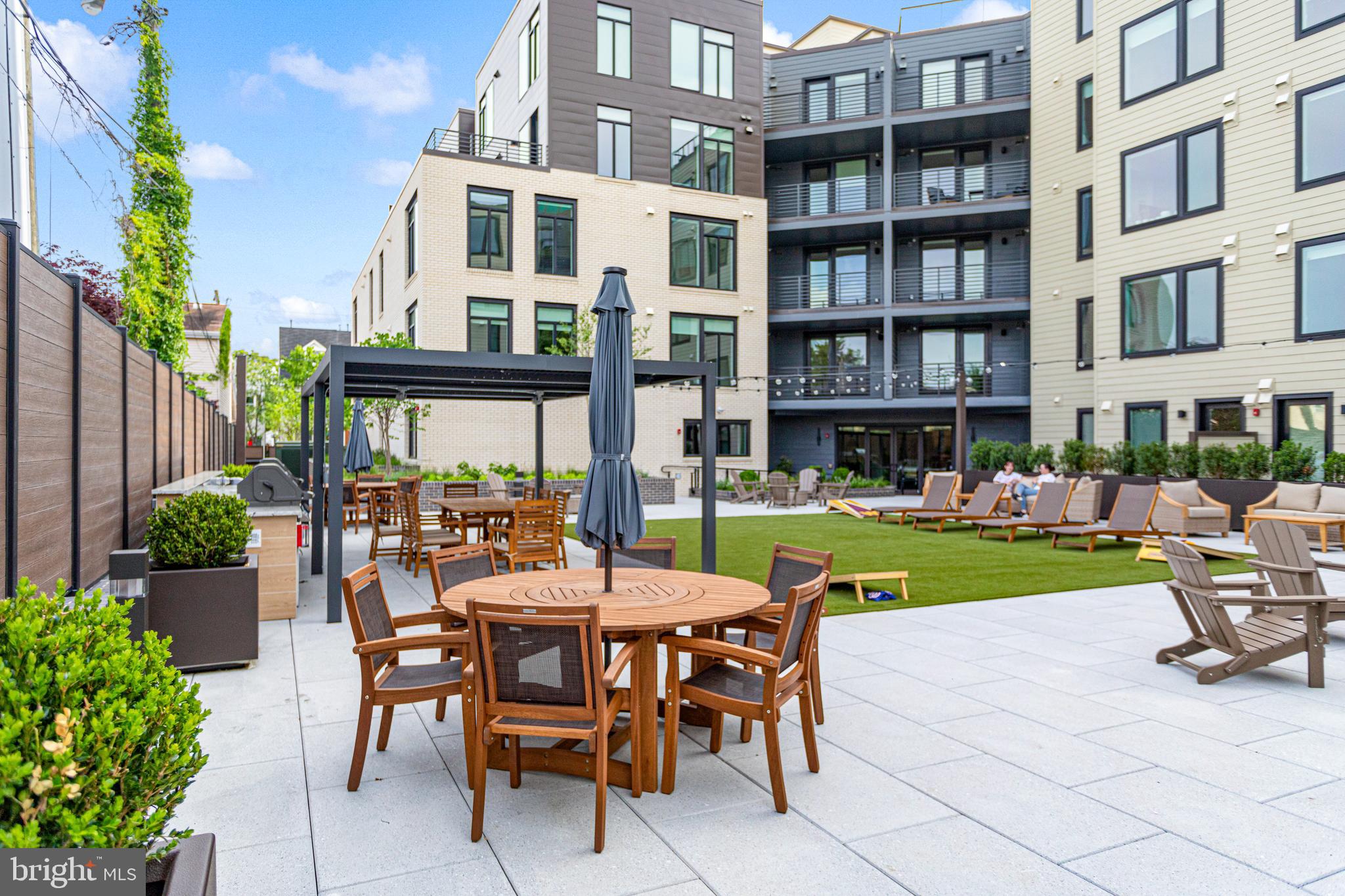 701 North Henry Street, Unit 204 Alexandria, VA 22314 - Photo 4 of 12 a view of a building with a dining table and chairs