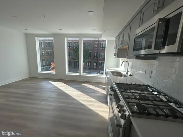 a kitchen with granite countertop a stove and a wooden floor