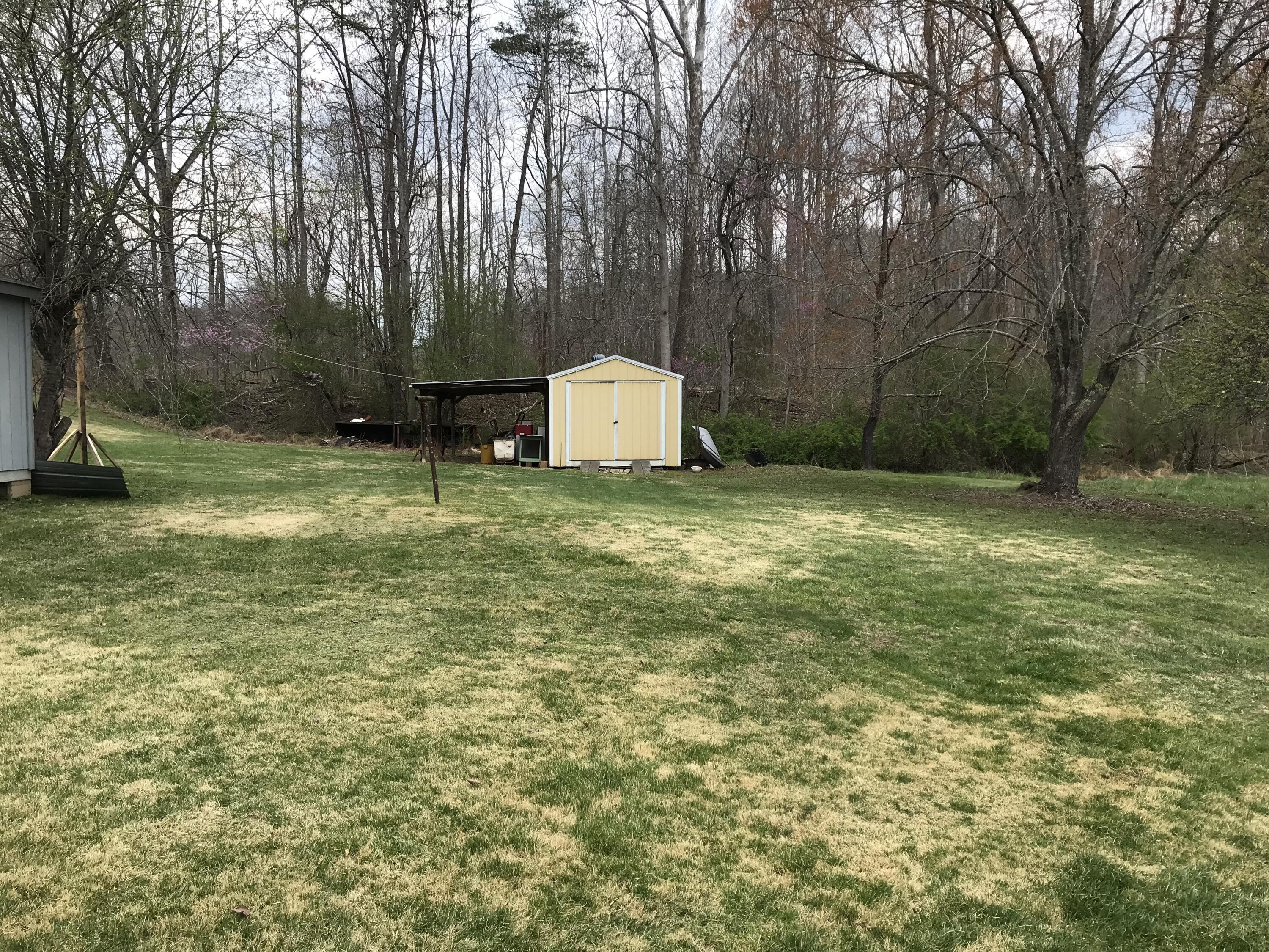 8180 Chatham Road Martinsville, VA 24112 - Photo 18 of 22 a yard with trees and a wooden fence