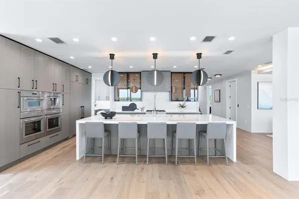 a large kitchen with stainless steel appliances kitchen island a large counter top