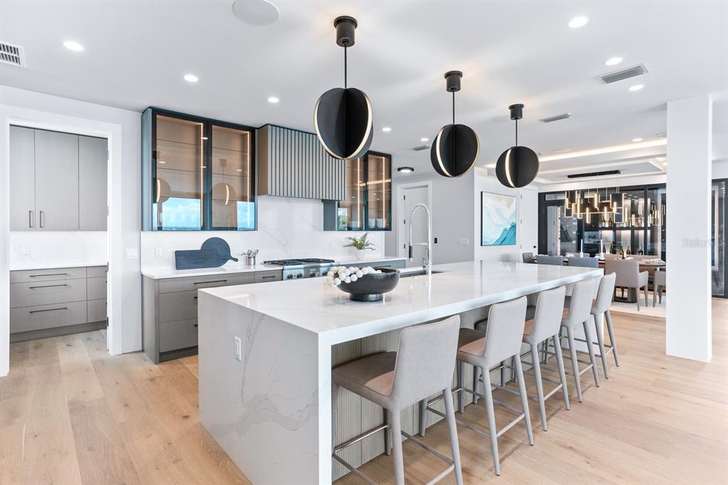 445 129th Avenue East Madeira Beach, FL 33708 - Photo 12 of 72 a kitchen with stainless steel appliances kitchen island a table and chairs in it
