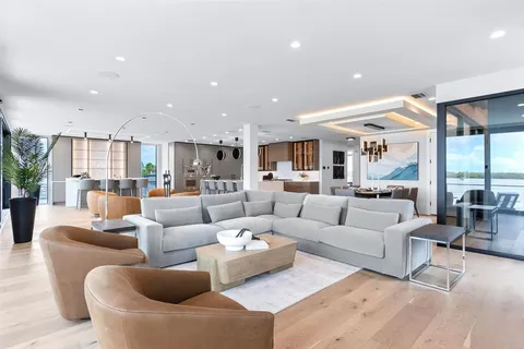 a large white kitchen with a large window and stainless steel appliances