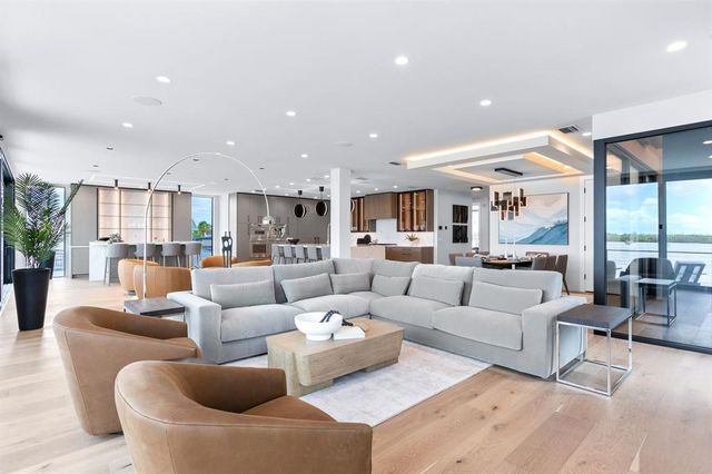 a large white kitchen with a large window and stainless steel appliances
