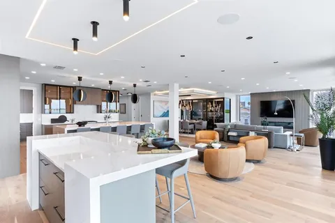 a kitchen with stainless steel appliances kitchen island a table and chairs in it