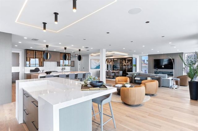 a kitchen with stainless steel appliances kitchen island a table and chairs in it