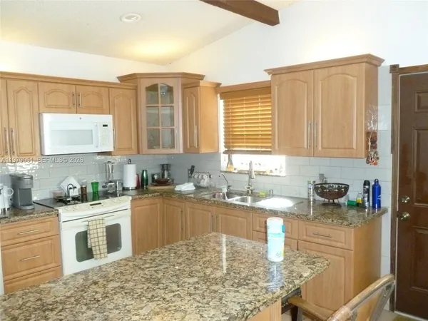a kitchen with stainless steel appliances granite countertop a sink stove and cabinets