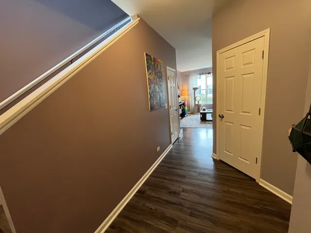 a view of a hallway with wooden floor and staircase