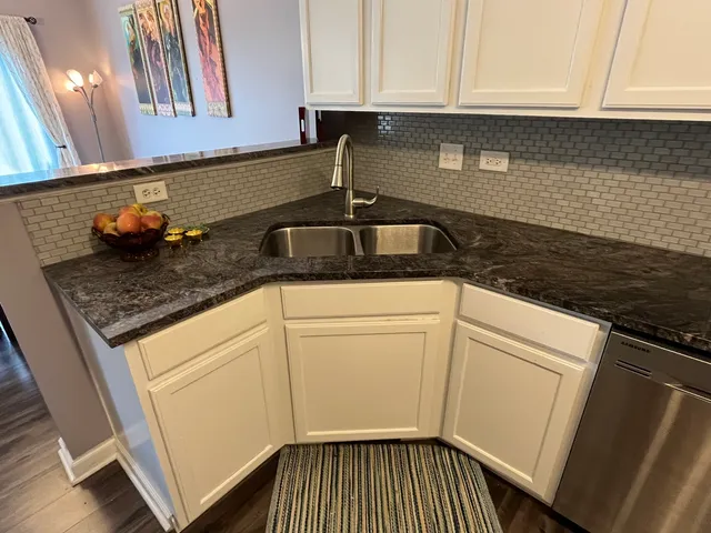 a kitchen with granite countertop a sink stove and cabinets