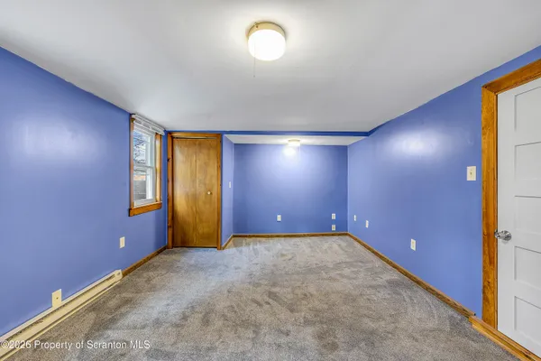 an empty room with windows and closet
