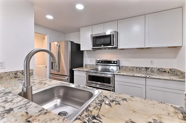 a kitchen with a sink stove and refrigerator