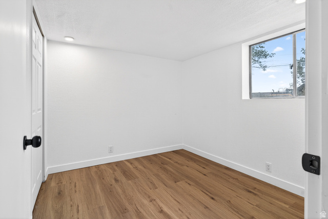 489 Owens Street Layton, UT 84041 - Photo 15 of 25 Unfurnished room with wood finished floors, recessed lighting, and a textured ceiling
