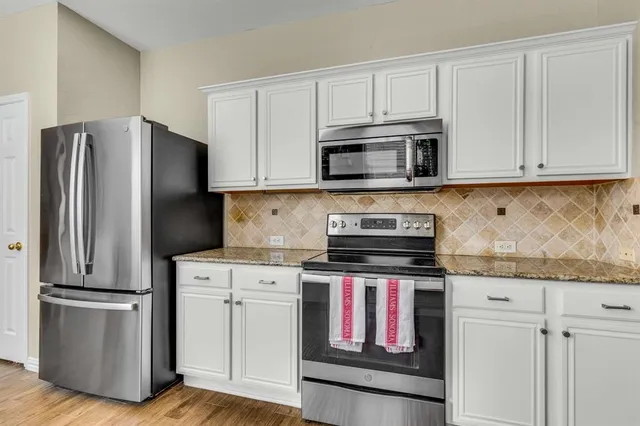 a kitchen with cabinets stainless steel appliances and a counter space