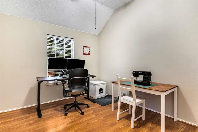 a view of a workspace with furniture and a window