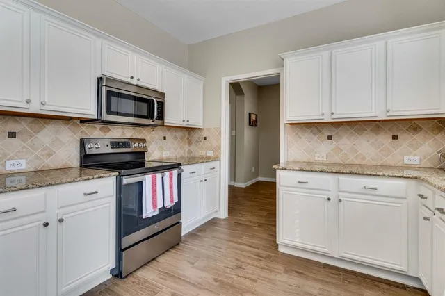 a kitchen with stainless steel appliances granite countertop a stove a sink and a microwave