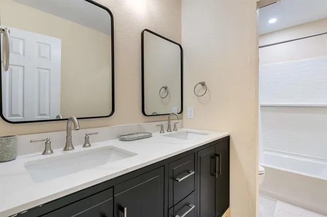 a bathroom with double vanity sinks and a mirror