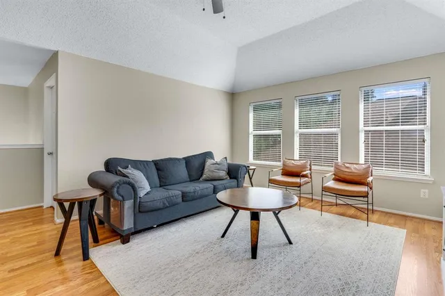 a living room with furniture a rug and a large window
