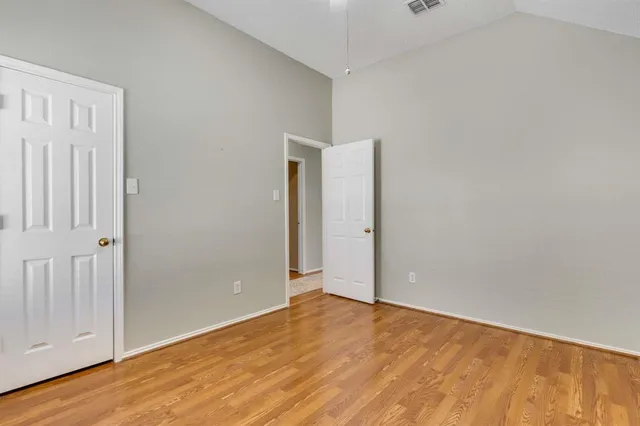 a view of an empty room with wooden floor