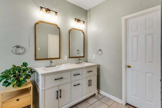 a bathroom with a double vanity sink and a mirror