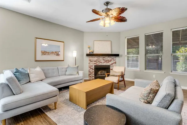 a living room with furniture a large window and a fireplace