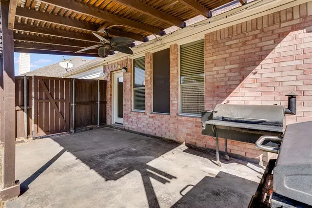 a backyard of a house with barbeque oven table and chairs